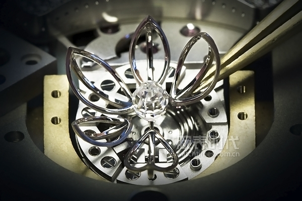 表盘中央椭圆形三角切面钻石的带动下,白色珍珠母贝上的花瓣徐徐绽放